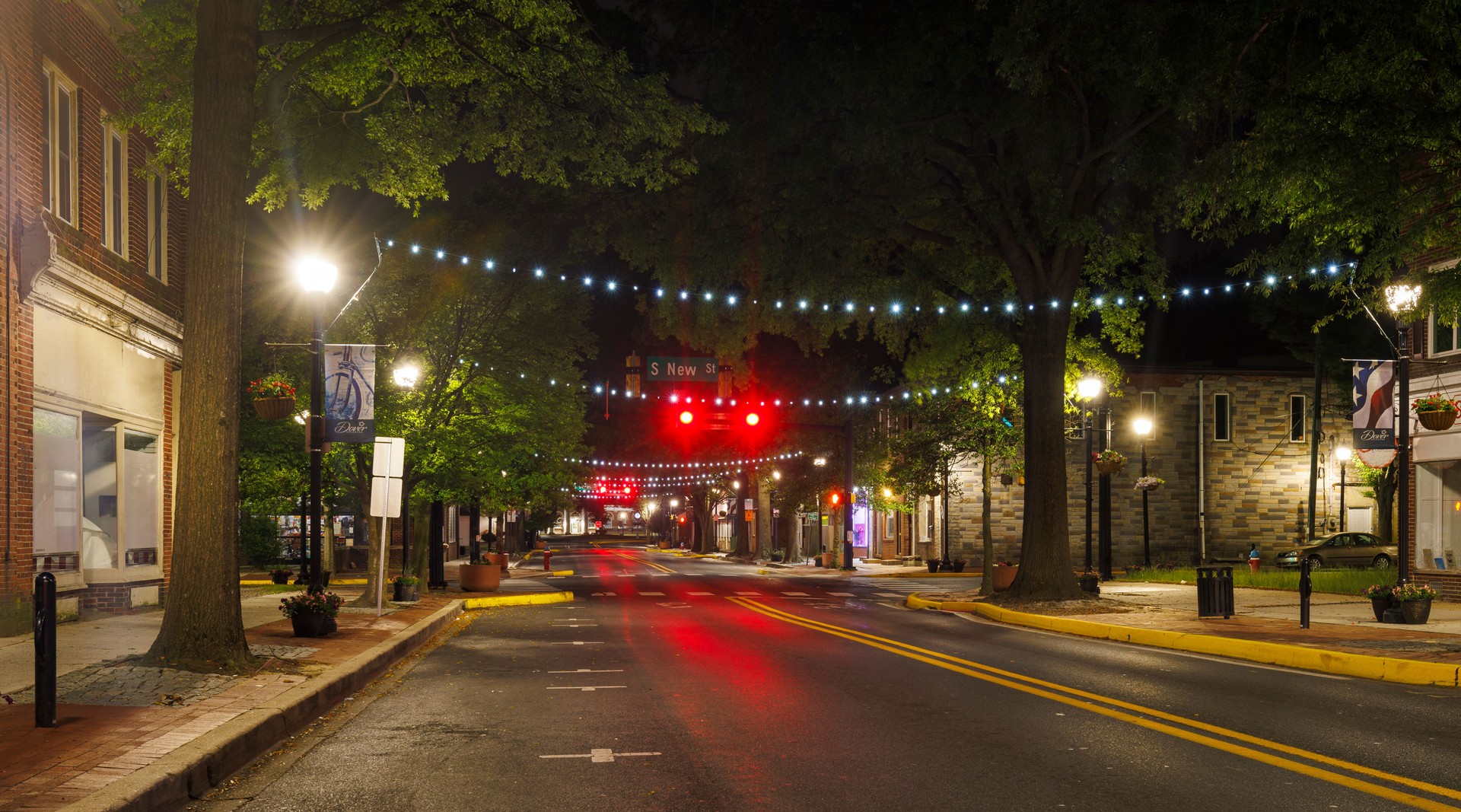 Downtown street and road illuminated at night. W Loockerman St with shops and houses is asleep in Dover, DE